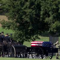 A horse drawn caisson carries the casket containing the remains of Sen. John McCain, R-Ariz., to his burial site at the United States Naval Academy Cemetery in Annapolis Maryland, Sunday. McCain died Aug. 25 from brain cancer at age 81. Sen. John McCain buried at Naval Academy alongside a longtime friend