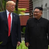 North Korean leader Kim Jong Un walks with U.S. President Donald Trump during a break in talks at their historic summit on Sentosa Island in Singapore in June. Second Kim-Trump summit could lay groundwork for arms control talks — and de facto nuclear state recognition