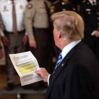 U..S President Donald Trump reads from an article praising his administration as he answers a journalist during a meeting with sheriffs at the White House in Washington Wednesday. Trump was responding to an anonymous “senior official” who wrote an op-ed article titled “I Am Part of the Resistance Inside the Trump Administration” in The New York Times on Wednesday. Senior Trump administration official writes editorial on White House 'resistance'