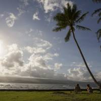 A Hawaiian and a Bulgaria visitor sit near Hilo Bay. Campaign calls on Hawaii island tourists to be respectful