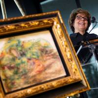 Sylvie Sulitzer speaks next to the painting Deux Femmes Dans Un Jardin by Pierre Auguste Renoir during a ceremony to return the painting, stolen by the Nazis in World War II from Ms. Sulitzer’s family, at the Jewish Heritage Museum in New York City Wednesday. Jewish collector's sole descendant gets Nazi-looted Renoir back