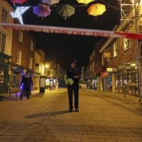 A police officer stands behind a cordon on the High Street in Salisbury, Britain, where police closed roads as a “precautionary measure” after two people were taken ill from the Prezzo restaurant (right in the background) Sunday. Police closed roads and called a hazardous response team Sunday night after two people became ill at the restaurant in the English city where a Russian ex-spy and his daughter were poisoned with a chemical nerve agent. Roads shut, hazmat team called after pair fall ill at eatery in U.K. city where ex-Russia spy was poisoned