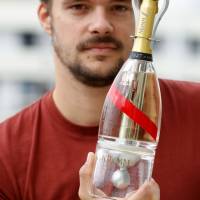 French designer Octave de Gaulle poses on Sept. 6 with Mumm Grand Cordon Stellar Champagne in a bottle he created for zero-gravity conditions. Champagne in space: Designer's bottle will let tourists sip spheres of bubbly
