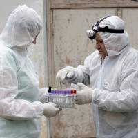 Inspectors Vija Ritina (left) and Igors Jermakovs prepare to process a check on a farm in the Rezekne region, after Latvia declared a state of emergency in the eastern part of the country, to fight an outbreak of African swine fever in some wild boars and domestic pigs in Latvia in 2014. Meat tracking said key to fight African swine fever: OIE
