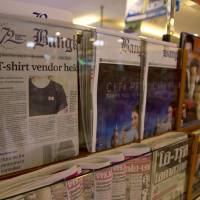 f thais-a 20180913 Thailand’s Bangkok Post newspaper depicting a cover story on the detention of a vender who sold black T-shirts bearing a symbol allegedly linked to a movement promoting a federal republic, is displayed in a newspaper stall in Bangkok Tuesday.Thailand’s military government this past week launched a crackdown on a small anti-government movement advocating a federal republic, arresting its alleged sympathizers on the basis of their owning T-shirts bearing the group’s logo of a tiny red and white flag. Thai junta sees red-white flag T-shirts as proof of sedition