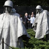 Vice President Mike Pence (center) listens to retired Army Col. Richard Dean, vice chairman of the Korean War Veterans Memorial Foundation, followed by Interior Secretary Ryan Zinke, at the start of a ceremony to present a American flag to the Korean War Veterans Memorial Foundation that was used during a ceremony in Hawaii in August for the return of remains from the Korean War, Thursday at the Korean War Veterans Memorial in Washington. U.S. eyes October talks with North Korea on hunt for remains of war dead