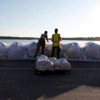 Members of the National Guard work on a long sand bag flood barrier being built by the South Carolina Department of Transportation on U.S. 501 to lesson damage to roads anticipated from floods caused by Hurricane Florence, now downgraded to a tropical depression, in Conway, South Carolina, Wednesday. Florence portends more massive, slow-moving hurricanes in age of global warming: scientists