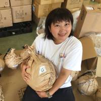 Ayumi Miyaura, who launched a fireworks show linking Ecuador to a Fukushima town in August, holds shell casings with wishes wrapped around them in this undated photo. Japanese pyrotechnician lights up Ecuador's skies to inspire kids, forge link with Fukushima