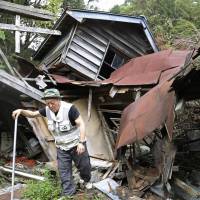 Yoshimitsu Kori, a resident of Atsuma, Hokkaido, the town hit hardest by the level 7 earthquake on Sept. 6, checks out the wreckage Sunday of what used to be his home. Quake damage to Hokkaido's farm, forestry, fishing sectors estimated at nearly ¥40 billion; dairy farmers in bind