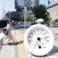 A woman walks past a thermometer showing the temperature topping 40 degrees in Nagoya on Aug. 6. Eastern Japan's summer hottest since 1946, meteorological agency says