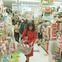 Treasure hunt: A shopper fills her basket in a Don Quijote outlet in Tokyo’s Shinjuku district. Will Don Quijote tilt its lance at the Amazon giant?