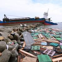 Two ships sit grounded on a breakwater strewn with debris at Amagasakinishinomiya Port in Hyogo Prefecture on Sept. 6 in the wake of Typhoon Jebi. The necessary calamity