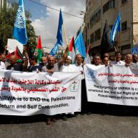 Palestinian protesters demonstrate against the U.S. cut in UNRWA funds in front of the Head office of the West Bank town of Hebron Sept. 8 . Trump's assault on Palestinian refugees