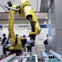 A robotic arm is demonstrated at an exhibit in Tokyo last April. Nidec Corp., with its knack for anticipating major business trends, has been investing heavily in robotics. Are robots all hype? Nidec may have the answer