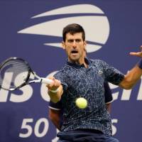 Novak Djokovic hits a return against Juan Martin del Potro during the U.S. Open final on Sunday in New York. Novak Djokovic outlasts Juan Martin del Potro to win U.S. Open title
