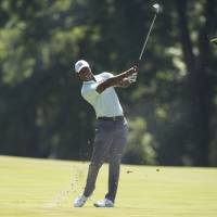 Tiger Woods hits from the fairway on the second hole during the first round of the BMW Championship on Thursday. Tiger fires 62, shares BMW lead