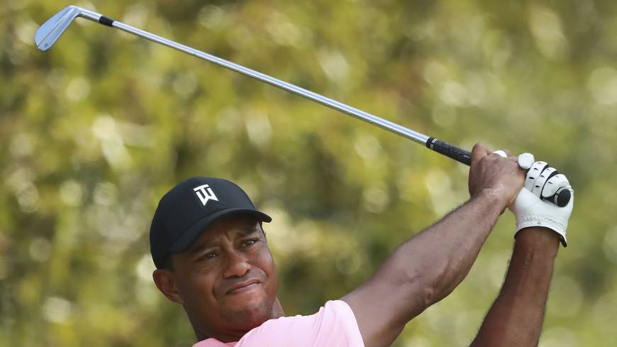 Tiger Woods watches his tee shot on the third hole in the first round of the Tour Championship in Atlanta on Thursday. Tiger Woods returns to Tour Championship with share of lead