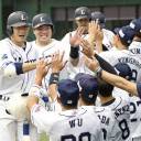 The Lions' Takumi Kuriyama (left) returns to the dugout after hitting a grand slam during the first inning of Seibu's 8-1 win over the Hawks on Monday at MetLife Dome.