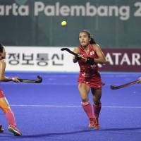 Motomi Kawamura (center) moves for the ball in the women’s field hockey final against India at the Asian Games on Friday night. Japan takes gold in field hockey