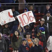 Red Sox fans hold up a 106 sign after the team’s franchise-record 106th win of the season against the Orioles at Fenway Park on Monday. BoSox set team mark with 106th win