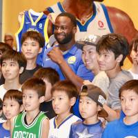 Golden State Warriors power forward Draymond Green pose for photos with participants at a Tokyo-area event on Saturday. Golden State Warriors star Draymond Green draws crowds in first Japan visit