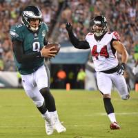 Philadelphia QB Nick Foles runs after catching a pass against Atlanta’s Vic Beasley in the third quarter on Thursday night. Eagles hold off Falcons in NFL season opener