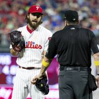 Philadelphia Phillies relief pitcher Austin Davis (left) talks with umpire Marty Foster during the eighth inning of a baseball game against the Chicago Cubs on Saturday in Philadelphia. Umpire confiscates Phillies pitcher's cheat sheet