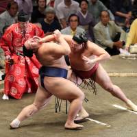 No. 4 maegashira Abi (right) launches an attack on No. 5 Asanoyama on the third day of the Autumn Grand Sumo Tournament. Kisenosato perseveres to stay undefeated at Autumn meet