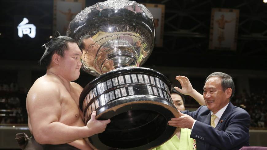 Hakuho receives the Prime Minister’s Cup from Chief Cabinet Secretary Yoshihide Suga on Sunday at Ryogoku Kokugikan. Hakuho won the basho with a 15-0 record. Hakuho wins battle of yokozuna to finish Autumn Basho with 15-0 record