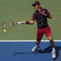 Kei Nishikori plays a shot from Germany’s Philipp Kohlschreiber in their fourth-round match at the U.S. Open on Monday. Nishikori storms into quarterfinals
