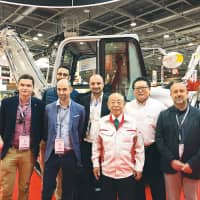 Akio Takeuchi, Founder of Takeuchi Mfg. Co., Ltd. and Hiroshi Komatsu, Managing Director of Takeuchi France SAS with customers at INTERMAT PARIS 2018 | TAKEUCHI