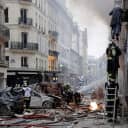 A woman is evacuated from an apartment by firefighters after an explosion occurred at a bakery on the corner of Rue Saint-Cecile and Rue de Trevise in central Paris early on Saturday.
