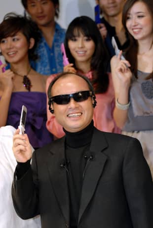 SoftBank Corp. chief Masayoshi Son poses with a product utilizing specially adapted Oakley sunglasses for audio portability during a promotional event in Tokyo in January 2007.