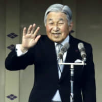 Emperor Akihito waves to well-wishers from the balcony of the Imperial Palace in Tokyo on Jan. 2, 2017. | KYODO