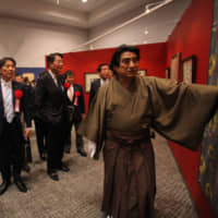 Haruhisa Handa, donning traditional Japanese attire, explains his works. | TACHIBANA PUBLISHING
