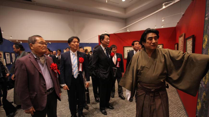 Haruhisa Handa, donning traditional Japanese attire, explains his works. | TACHIBANA PUBLISHING