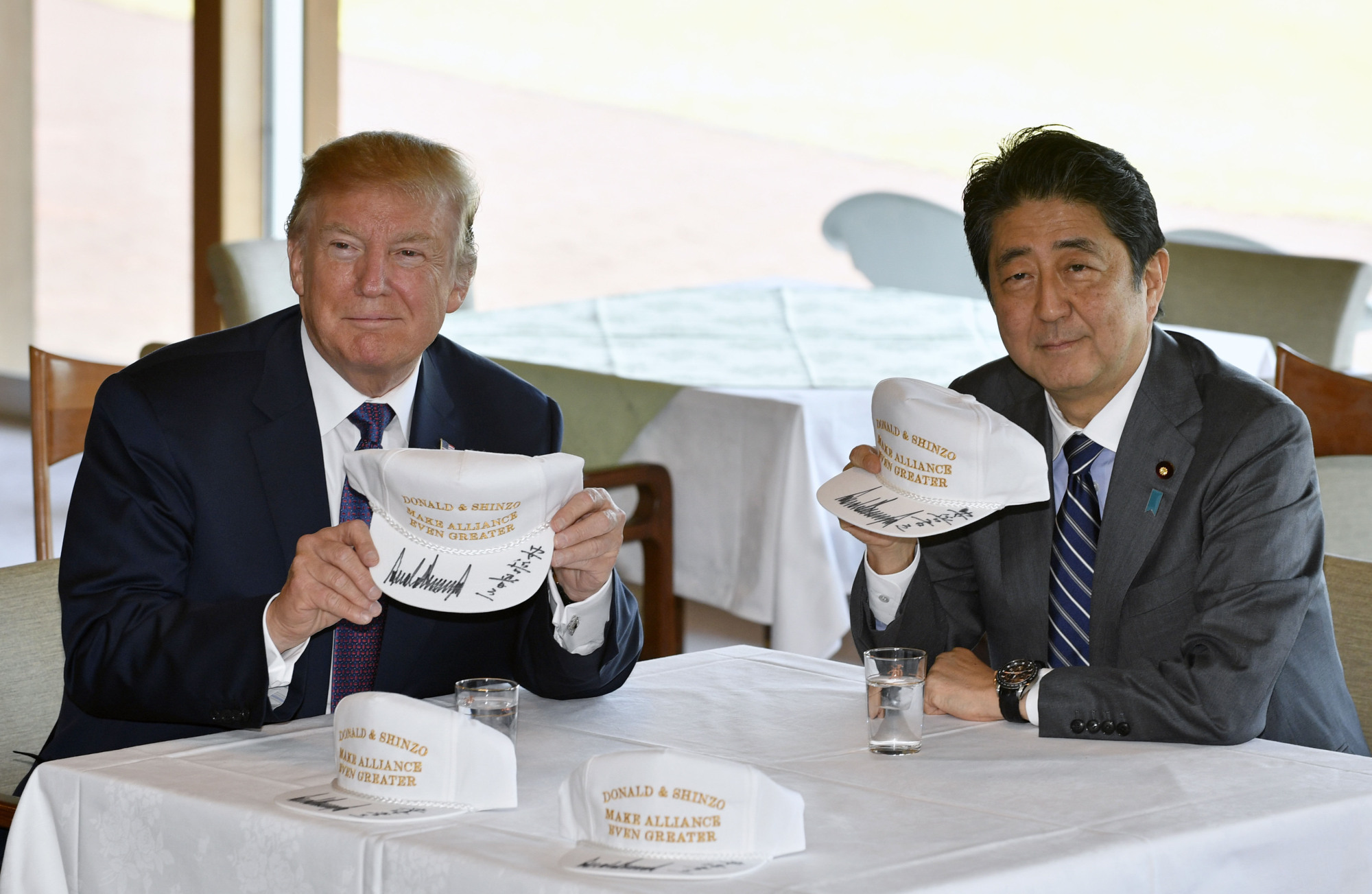 Trump and Abe pose after signing hats reading 'Donald and Shinzo, Make Alliance Even Greater' at the Kasumigaseki Country Club in Kawagoe, near Tokyo, on Nov. 5. | AP