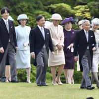 Members of the imperial family walk together at an imperial garden party in April 2018. | KYODO