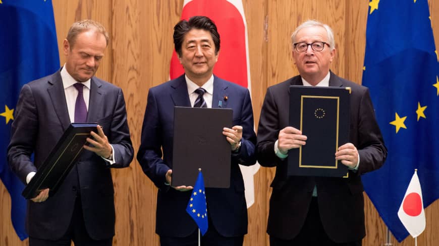 European Council President Donald Tusk, Prime Minister Shinzo Abe and European Commission President Jean-Claude Juncker hold up the signed versions of the economic partnership agreement and the strategic partnership agreement in Tokyo last July. | ETIENNE ANSOTTE, EUROPEAN UNION