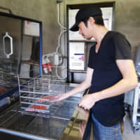 A worker uses a Rapid Freezer unit  developed by the company. | SARAYA CO.