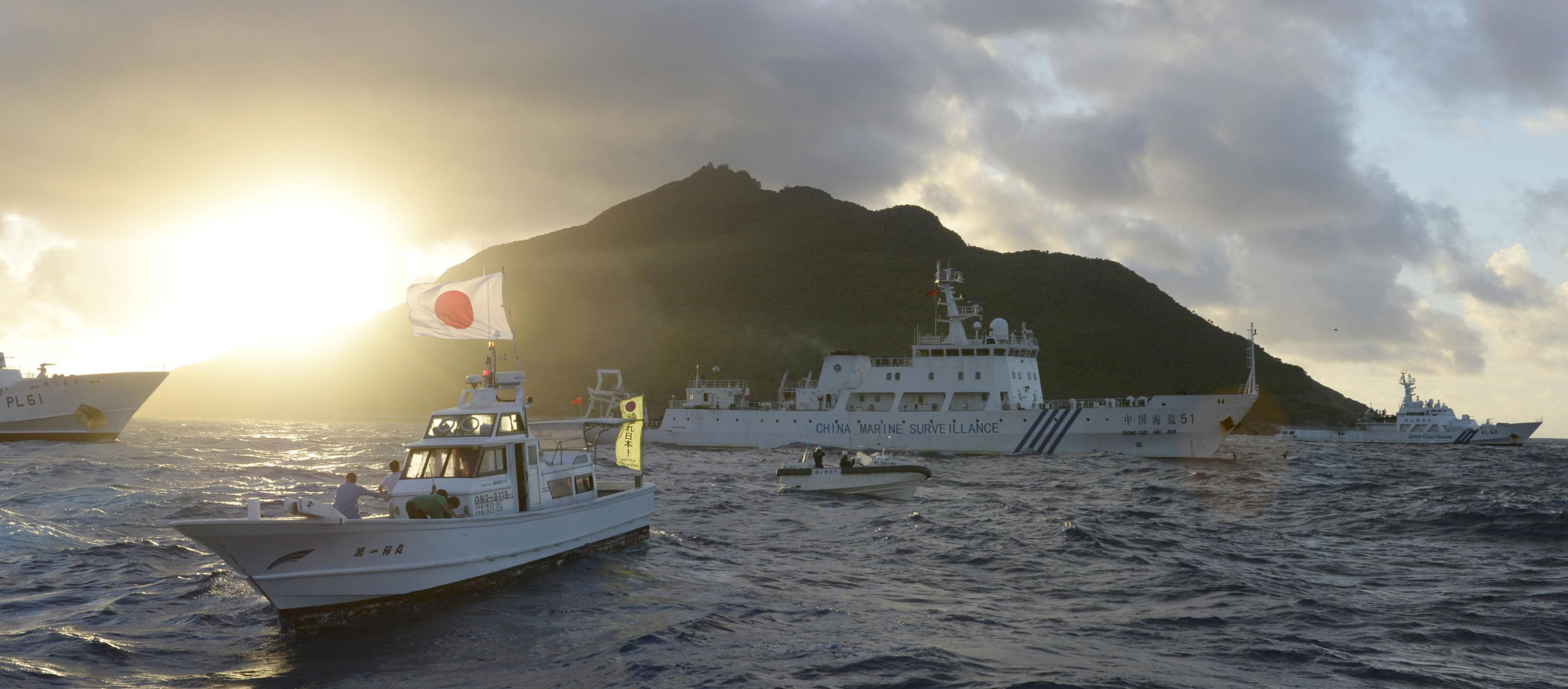 A Chinese maritime surveillance vessel (center back) passes near Uotsuri Island, part of the disputed Senkaku Islands in the East China Sea, in July 2013. | KYODO
