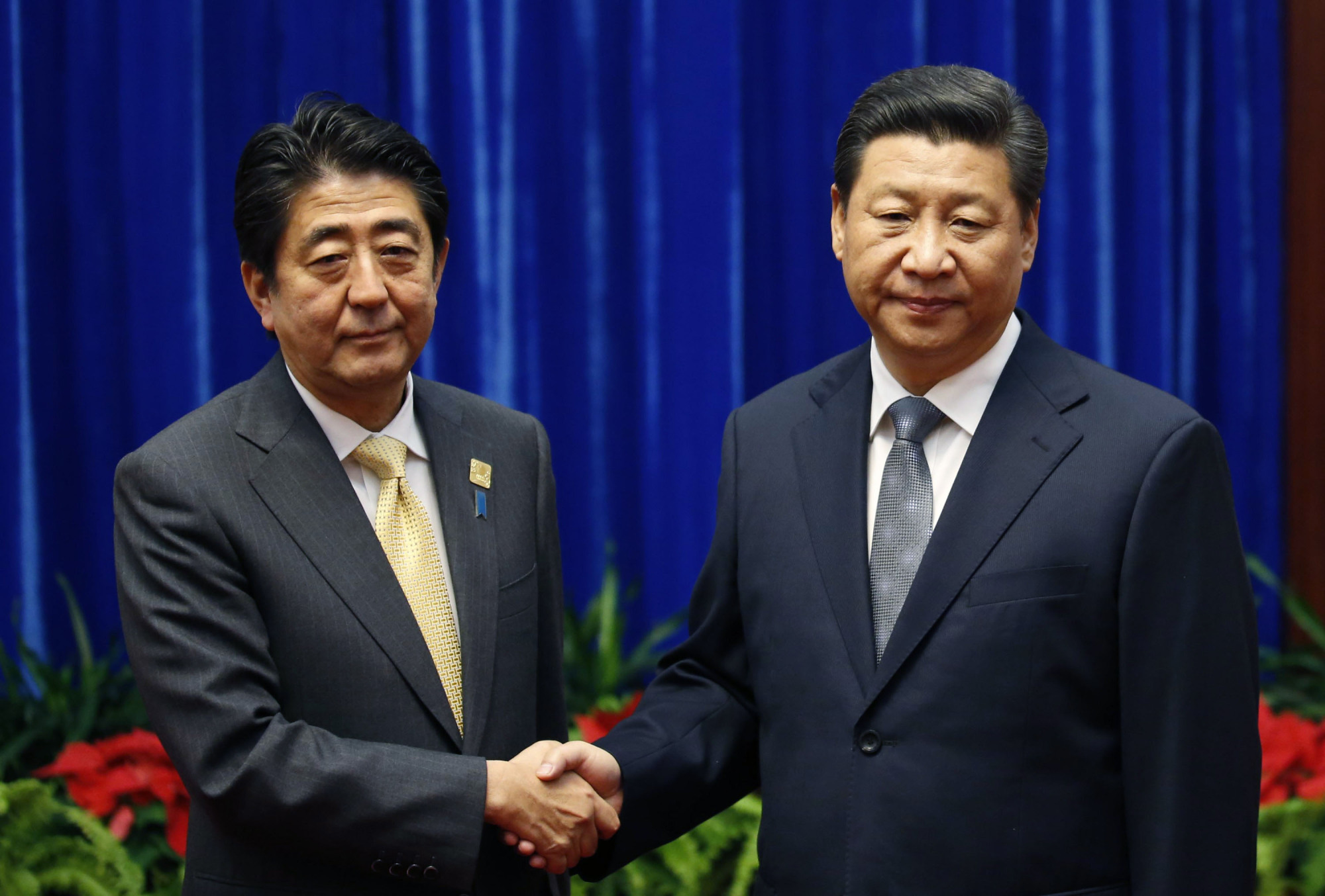 Prime Minister Shinzo Abe and Chinese leader Xi Jinping shake hands during their meeting at the Great Hall of the People, on the sidelines of the Asia-Pacific Economic Cooperation summit, in Beijing on Nov. 10, 2014. The uneasy handshake marked the first meeting between the two men since either took power, and an awkward first gesture toward easing two years of high tensions. | AP