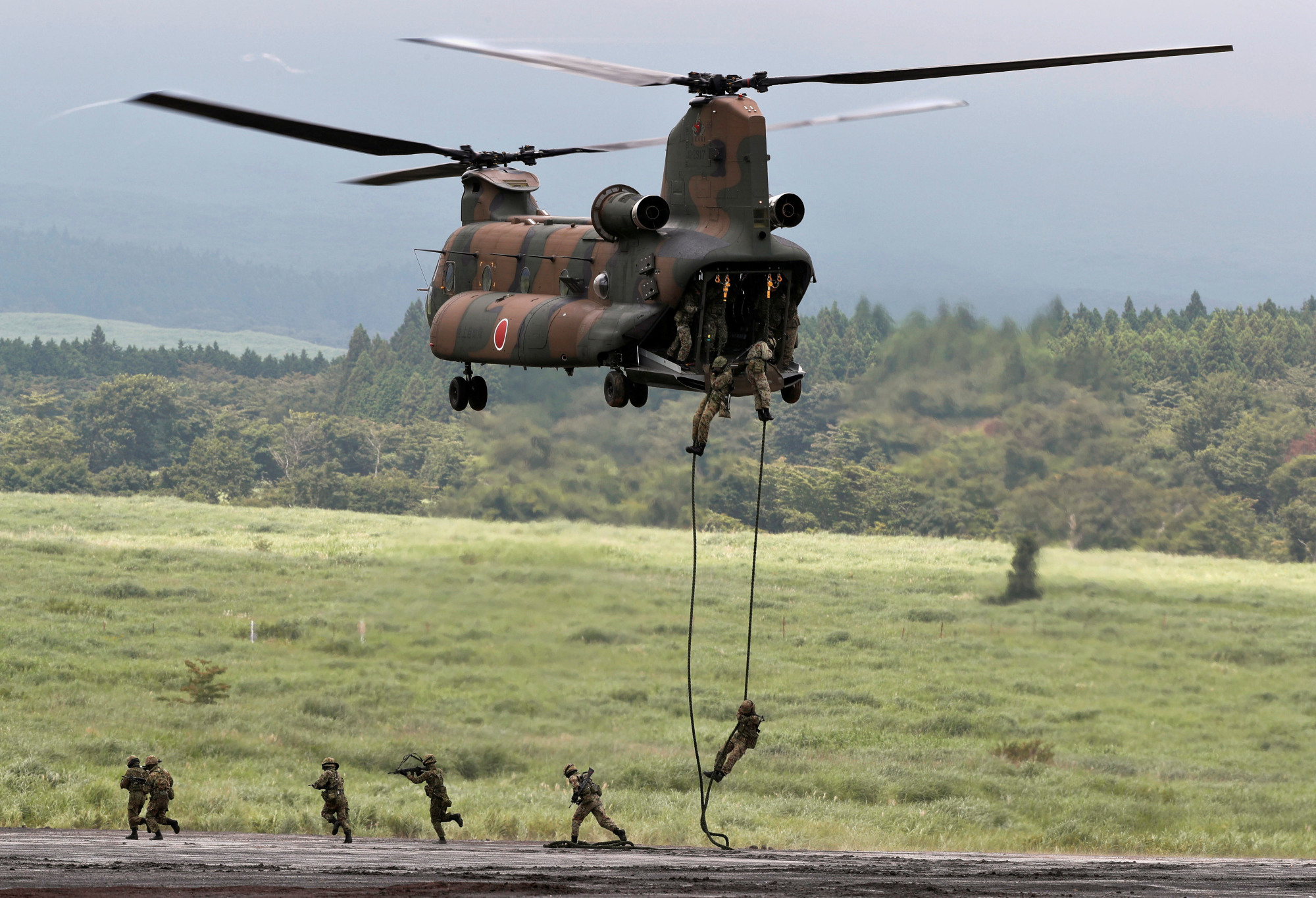Ground Self-Defense Force soldiers rappel from a CH-47 Chinook helicopter during an annual training session near Mount Fuji at Higashifuji training field in Gotemba, Shizuoka Prefecture, on Aug. 22. | REUTERS