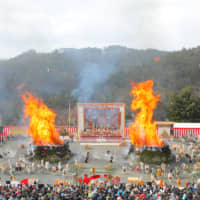 After lighting, bright orange flames burst out of the two gomadan pyres at the center of the amphitheater at the Agon Shu Fire Rites Festival in Kyoto on Feb. 9. | AGON SHU
