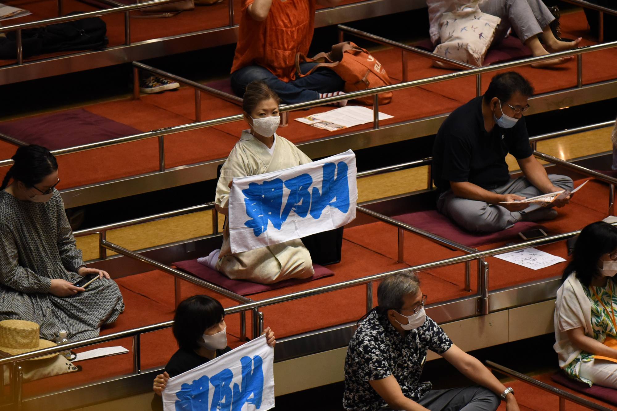 A fan holds up a towel bearing ozeki Asanoyama's name. | DAN ORLOWITZ 