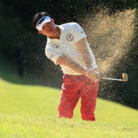 Kunihiro Kamii, who won the tournament at 21-under, hits out of a bunker. | 
