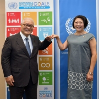 Liberal Democratic Party Upper House member Keizo Takemi (left) and Director of the United Nations Information Centre Kaoru Nemoto bump fists after their discussion in September. | YOSHIAKI MIURA