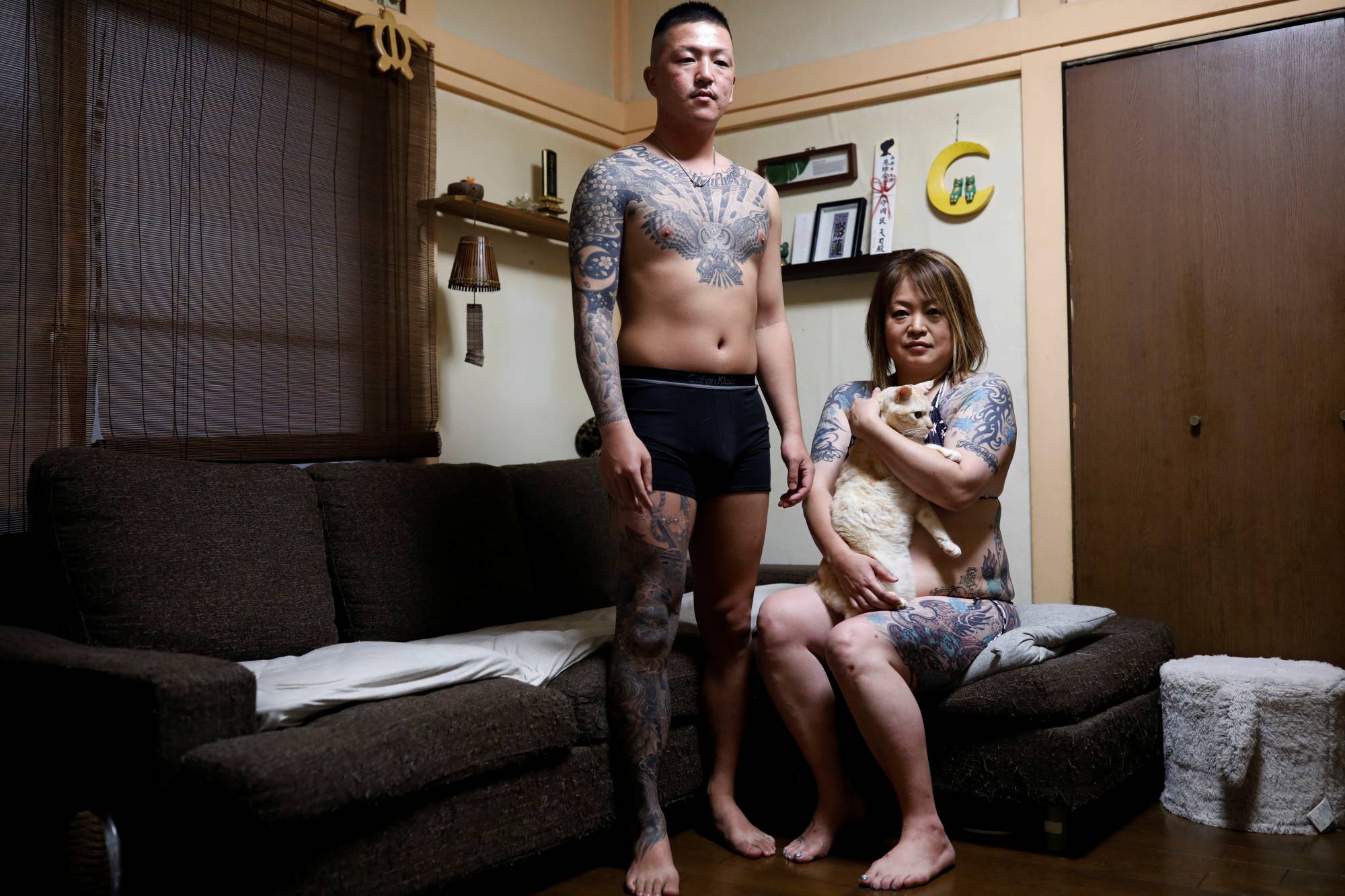 Mari Okasaka, 48, and her son Tenji Okasaka, 24, pose for photographs at their home in Niiza, Saitama Prefecture, on Sept. 25. | REUTERS