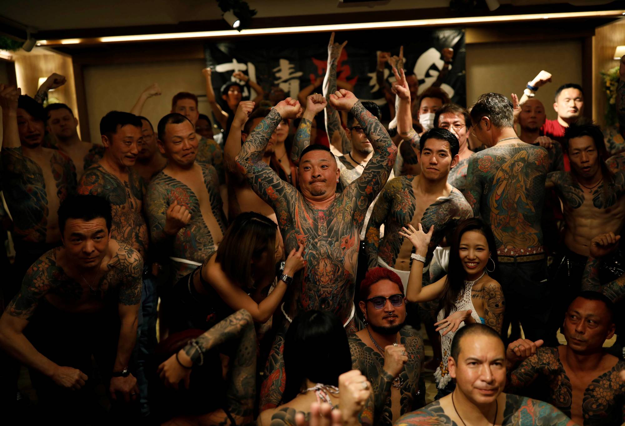 People with tattoos gather together for group photos at the annual gathering of the Irezumi Aikokai (Tattoo Lovers Association) in Tokyo in February. | REUTERS