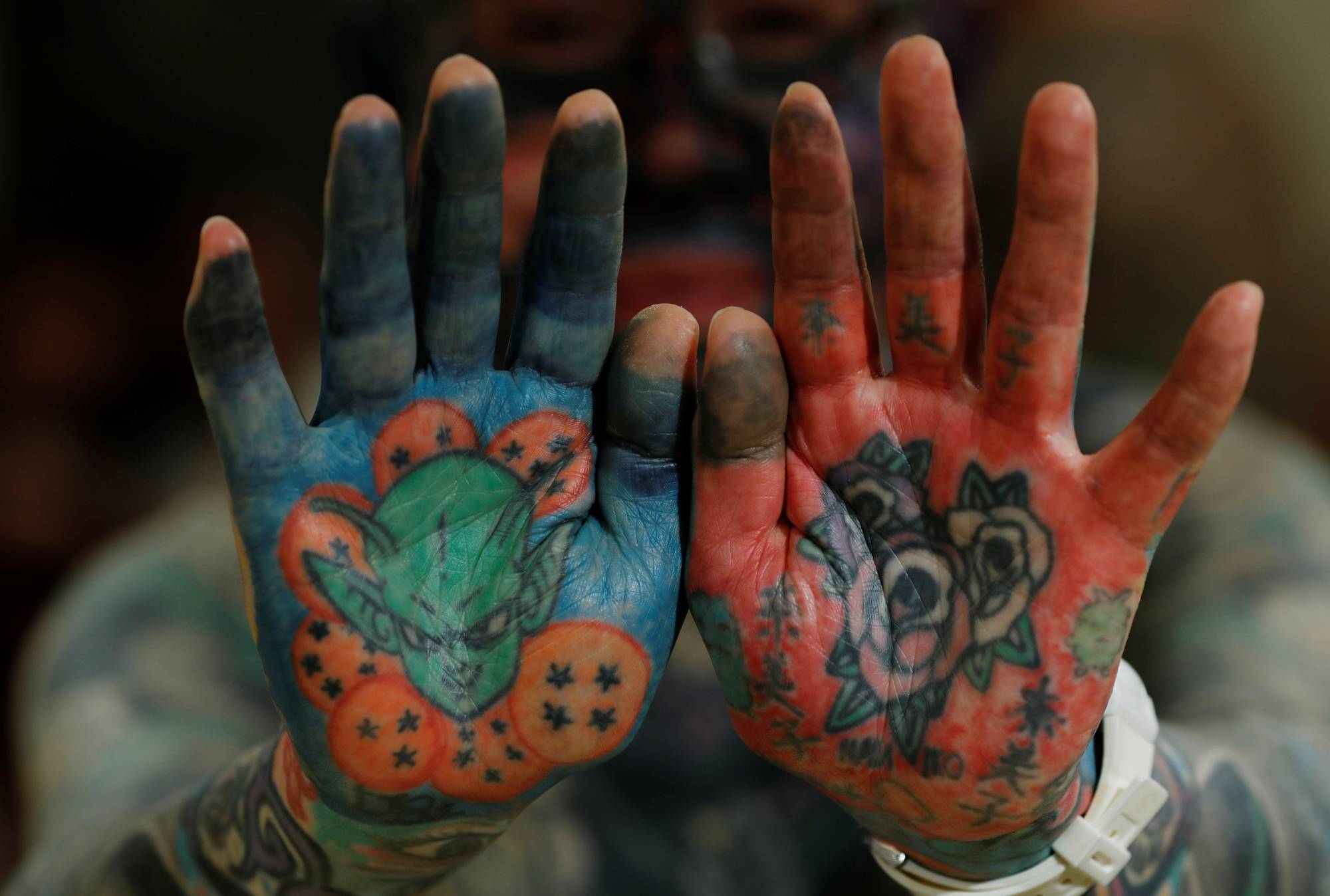 Author Hiroki Takamura, 62, shows off tattoos on his palms at the annual gathering of the Irezumi Aikokai (Tattoo Lovers Association) in Tokyo in February. | REUTERS